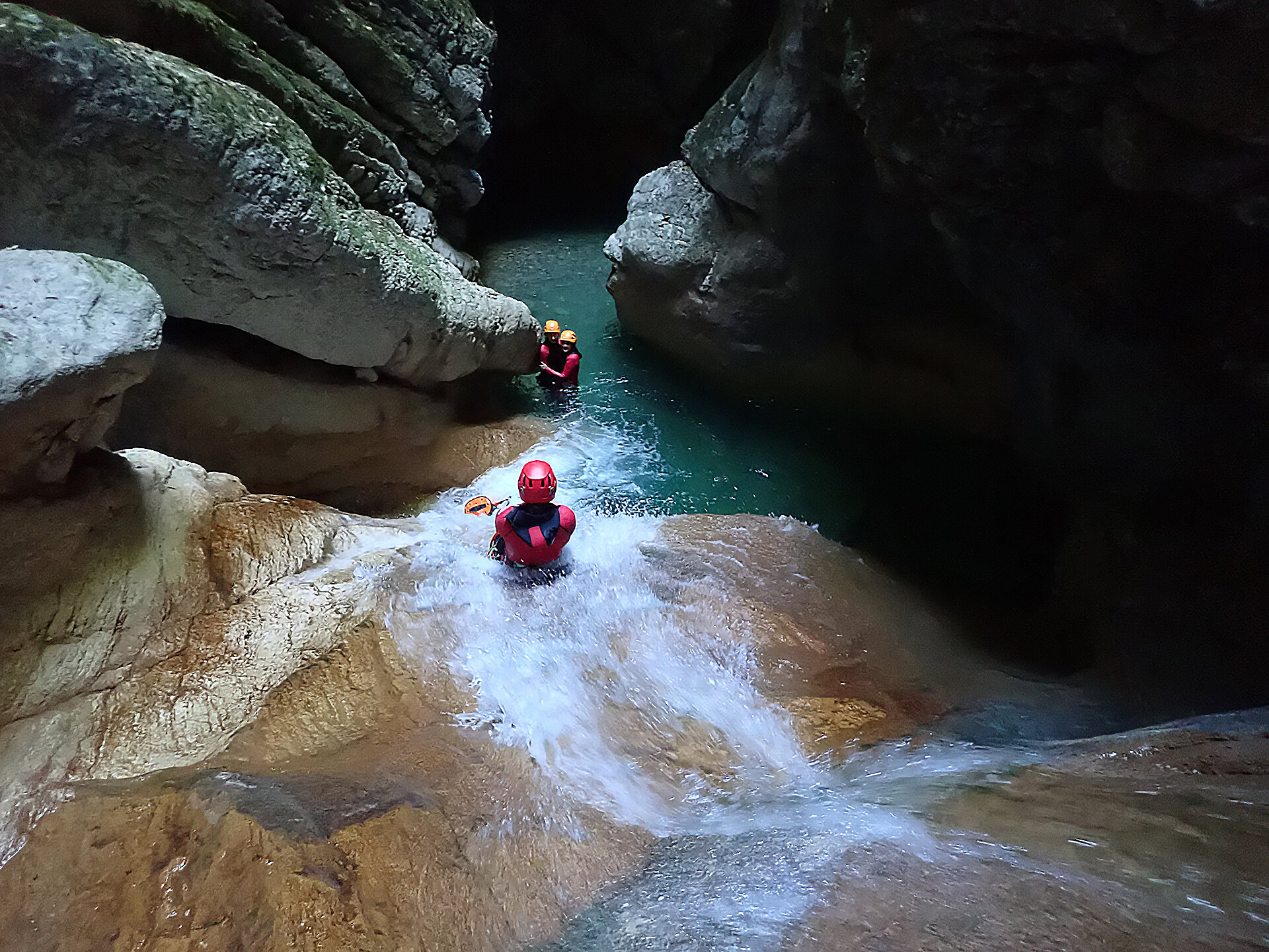 Une personne fais un toboggan dans le canyon de l'Infernet.