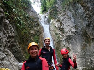 Trois canyoneurs avancent dans une vasque du canyon du Versoud