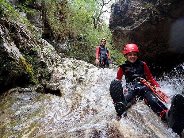 Un enfant qui fais un toboggan dans le canyon du Versoud, dans le Vercors, proche de Grenoble.