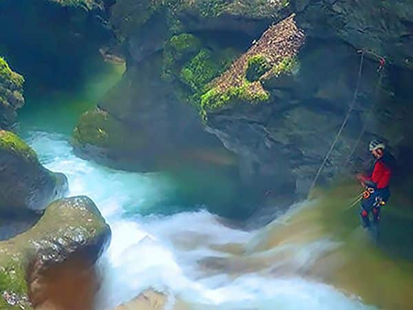 Vincent, guide de canyoning, est devant un toboggan dans le canyon de l'Infernet en Chartreuse à deux pas de Grenoble