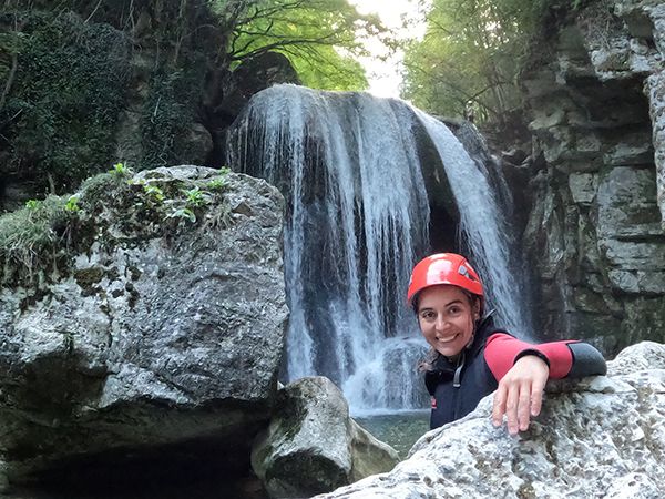 Une femme qui prend la pose accoudée à un roché devant une cascade du Furon, canyon dans le Vercors à 10 minutes de Grenoble