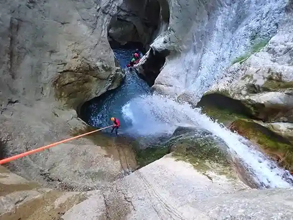 Canyoneur en rappel au-dessus d’une cascade dans l’Écouges intégral, journée sportive