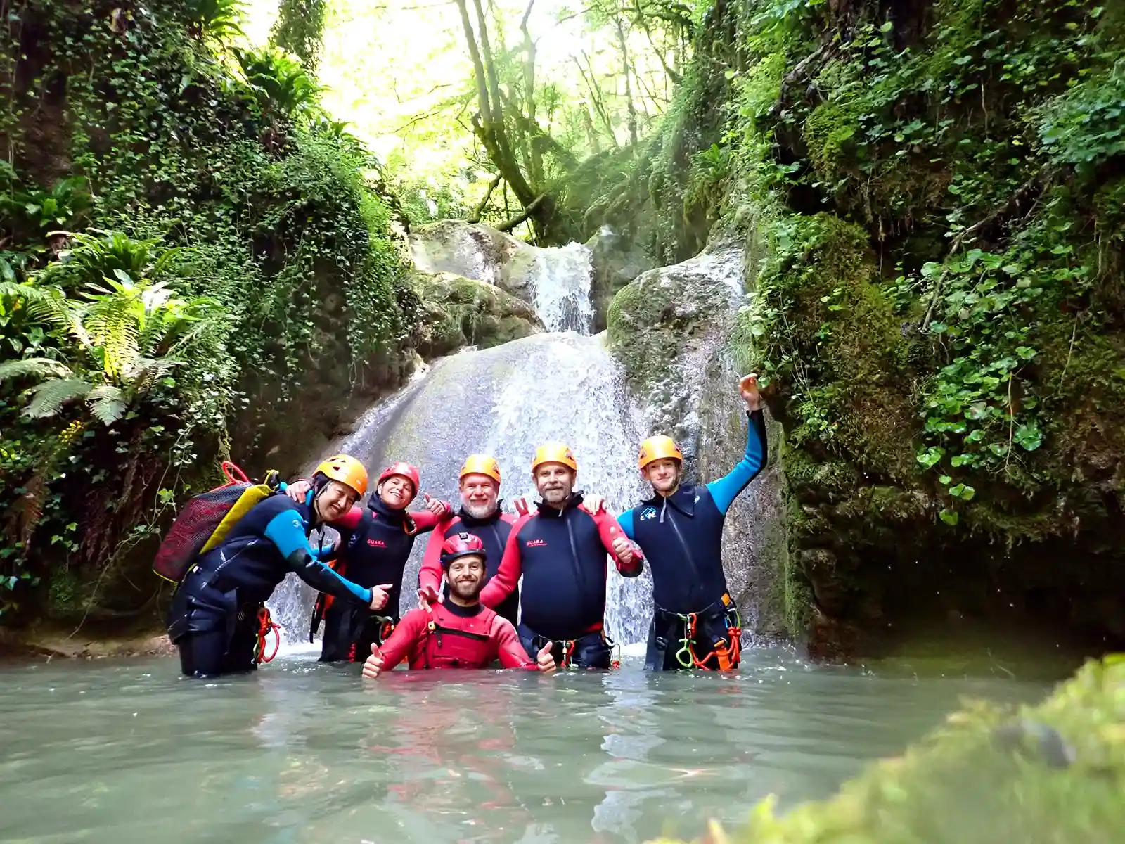 Groupe dans une vasque sous une cascade au ruisseau des Carmes, sortie canyoning accessible dans le Vercors.