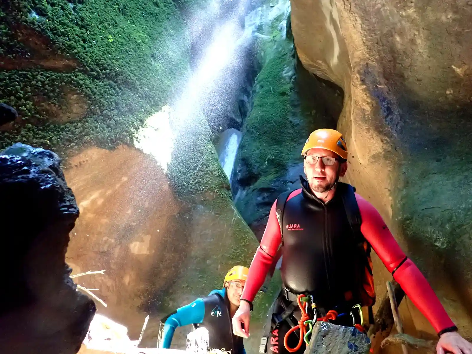Guide en canyon au ruisseau des Carmes dans le Vercors, avec une cascade en arrière-plan.