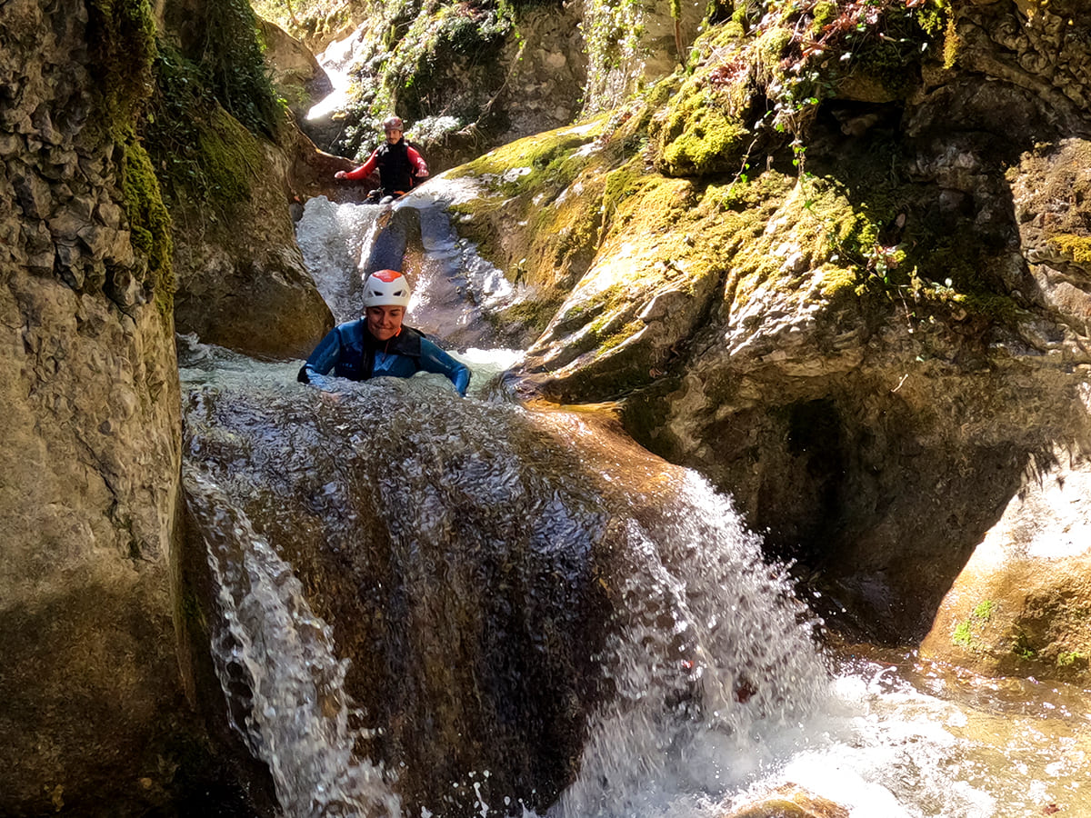 Participant sur un toboggan rocheux dans le canyon de la Pissarde