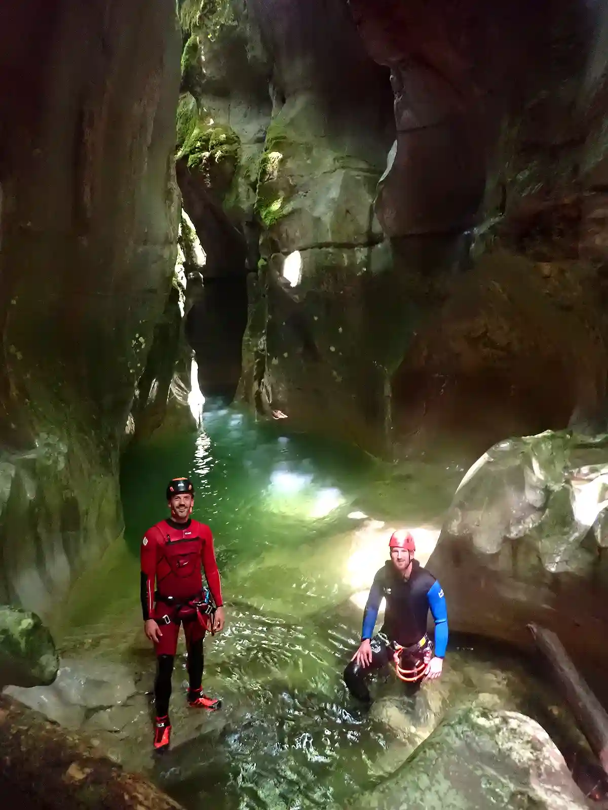 Deux canyoneurs dans l'encaissement spectaculaire du canyon du Groin, vasques vertes et parois sculptées, massif du Bugey dans l'Ain