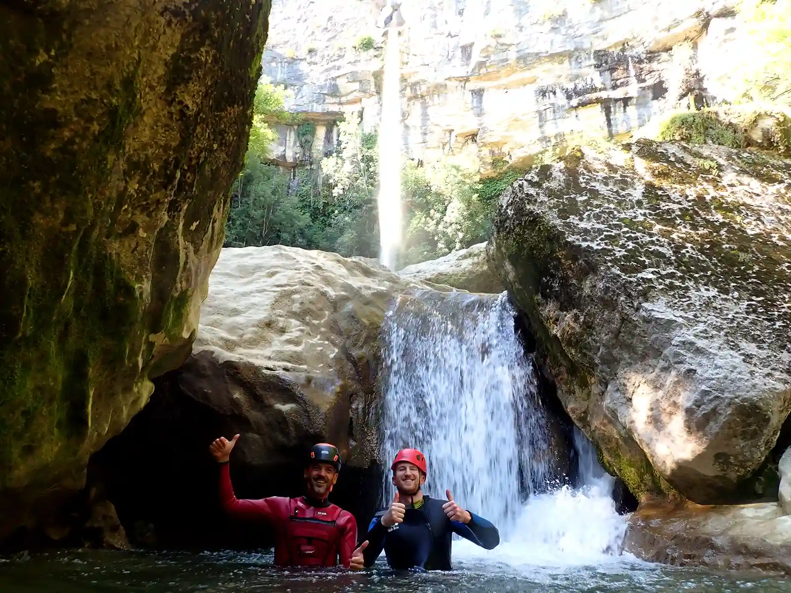 Deux canyoneurs au pied de la cascade de Cerveyrieu après le rappel de 60 mètres, canyoning dans l'Ain