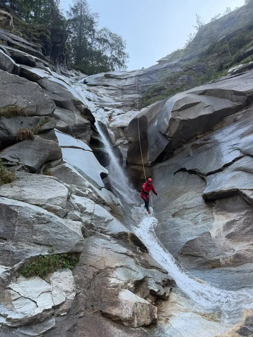 Rappel dans une cascade sur une dalle de gneiss, canyon de Gondo